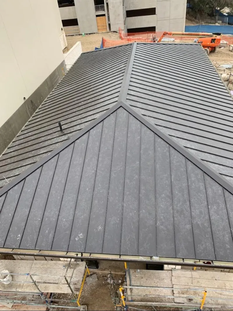 Commercial metal roof construction with crane equipment in West Monroe